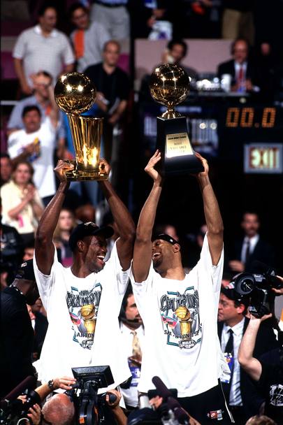 Gli Spurs vincono il primo titolo della loro storia battendo 4-1 in finale New York. L&#39;Ammiraglio David Robinson, che ha adottato Duncan dal suo arrivo in NBA, solleva il Larry O&#39;Brien Trophy. Duncan il premio di mvp delle Finals.